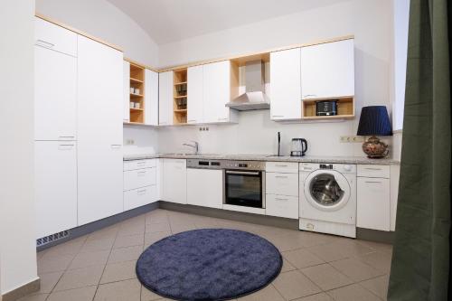 a kitchen with white cabinets and a washing machine at Belvedere City Apartment in Vienna
