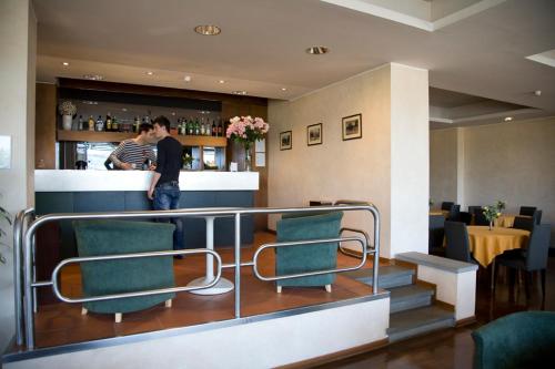 dwoje osób stojących przy barze w restauracji w obiekcie Hotel Barberino w mieście Barberino di Mugello