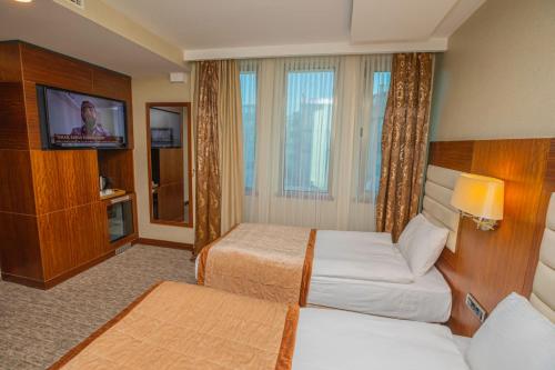 a hotel room with two beds and a flat screen tv at Akman Premium Hotel in Ankara