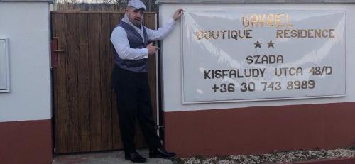 a man is standing next to a sign at Gavriel Boutique Residence Wellness Spa in Szada