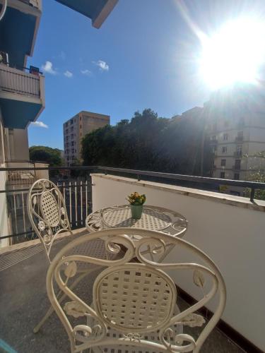 a table and chairs on a balcony with the sun at Porto Sicuro Hospitality in Cagliari
