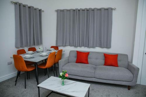 a living room with a couch and a table with orange pillows at Brookland Avenue in Sunderland