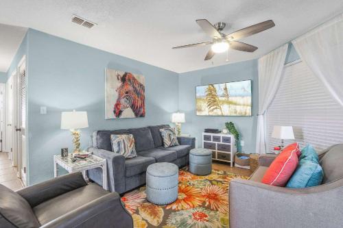 a living room with a couch and a ceiling fan at Sandpiper 1C- Stylish Gulf-side affordable in Gulf Shores