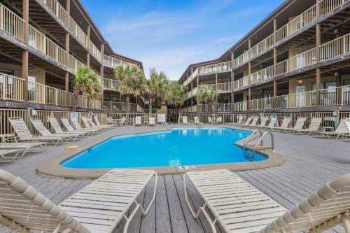 a swimming pool in the middle of a building with chairs at Sandpiper 1C- Stylish Gulf-side affordable in Gulf Shores