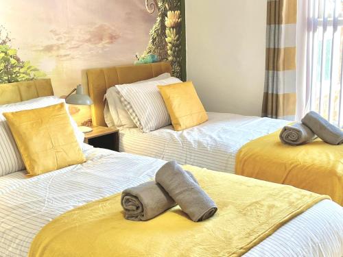 a room with two beds with towels on them at Modern 4-bed stay-away-home sleeps 8 in Preston in Preston