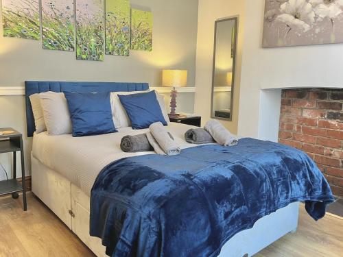 a bedroom with a bed with a blue comforter at Modern 4-bed stay-away-home sleeps 8 in Preston in Preston