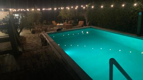 a swimming pool lit up at night with lights at La casa in Uchizy