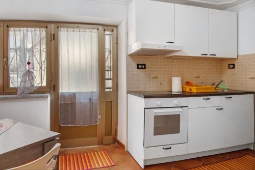 a kitchen with white cabinets and a window at Small House Monferrato in Fontanile