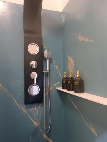 a bathroom with a shower with a blow dryer and bottles of soap at Porto Sicuro Hospitality in Cagliari
