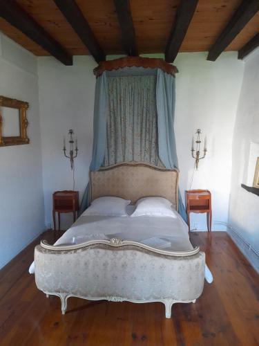 une chambre avec un lit blanc à baldaquin dans l'établissement Lo Vielh Ostal, à Saint-Paul-Lizonne