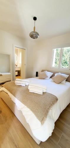 - une grande chambre blanche avec un grand lit dans l'établissement Villa vue mer à Antibes classée 4 étoiles-Piscine chauffée, à Antibes