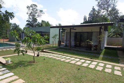 a small house with a garden in front of it at Maho Boutique Hotel in Anuradhapura