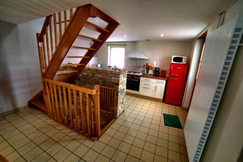 - une cuisine avec un escalier et un réfrigérateur rouge dans l'établissement Gîte de la Créche, à Wimereux