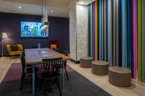 a dining room with a table and chairs and colorful curtains at Aloft Memphis Downtown in Memphis