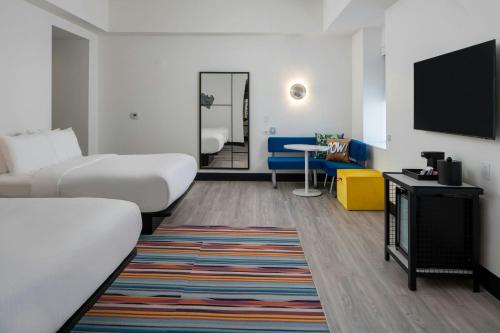 a hotel room with a bed and a flat screen tv at Aloft Memphis Downtown in Memphis
