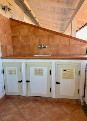 a kitchen with three doors and a sink at Apartment San Nicola Arcella in Saracena