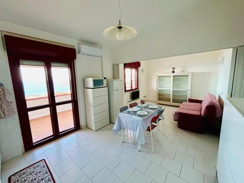 a kitchen and living room with a table and a couch at Apartment San Nicola Arcella in Saracena