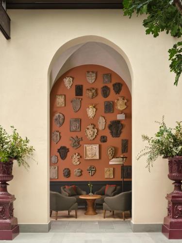 an archway with plates on a wall with chairs at Collegio alla Querce, Auberge Collection in Florence