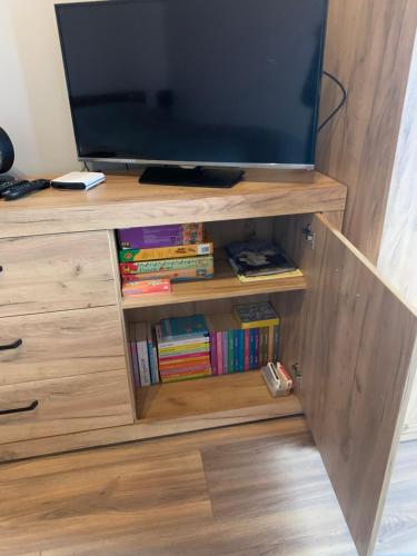 a wooden entertainment center with a flat screen tv at Bulwar Apartament Stare Miasto in Głogów