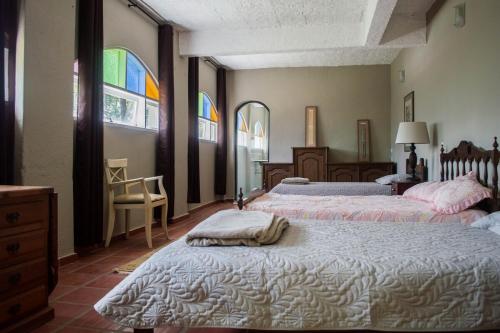 a bedroom with two beds and stained glass windows at Sitio and Beach Tennis in Itatiba