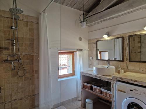 une salle de bain avec un lavabo et une machine à laver dans l'établissement Le Mas Joyeux - L'Olivier - Gîte En Cévennes, à Saint-Florent-sur-Auzonnet