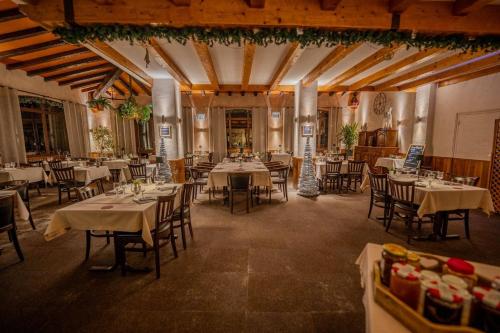 un restaurant avec des tables et des chaises dans une salle dans l'établissement Hôtel du Centre, à Valloire