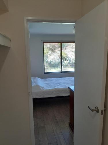 a small bedroom with a bed and a window at Red Kennel Budget Private Rooms - Trott Park in Happy Valley
