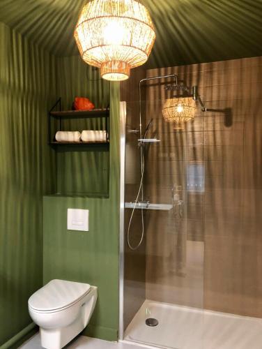 La salle de bains est pourvue d'une douche, de toilettes et de lustres. dans l'établissement Appartement Design aux Porte de Paris, à Romainville