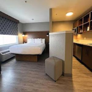 a hotel room with a bed and a kitchen at Hawthorn Extended Stay by Wyndham Bedford - Dallas in Bedford