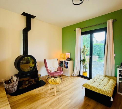 - un salon avec un poêle à bois et une chaise dans l'établissement Maison Familiale tout confort, à Mouen