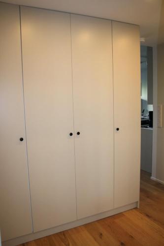 a closet with white cabinets in a room at Air conditioned condo downtown with lake view in Hämeenlinna