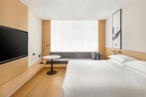 a hotel room with a bed and a flat screen tv at Fairfield by Marriott Changshu Hi-Tech Zone in Changshu