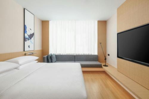 a hotel room with a bed and a flat screen tv at Fairfield by Marriott Changshu Hi-Tech Zone in Changshu