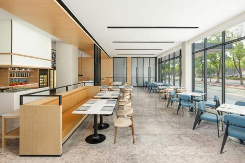 a cafeteria with tables and chairs and windows at Fairfield by Marriott Changshu Hi-Tech Zone in Changshu