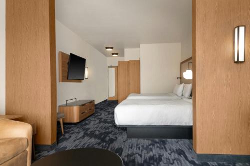 a hotel room with a bed and a flat screen tv at Fairfield by Marriott Inn & Suites Kansas City at The Legends in Kansas City