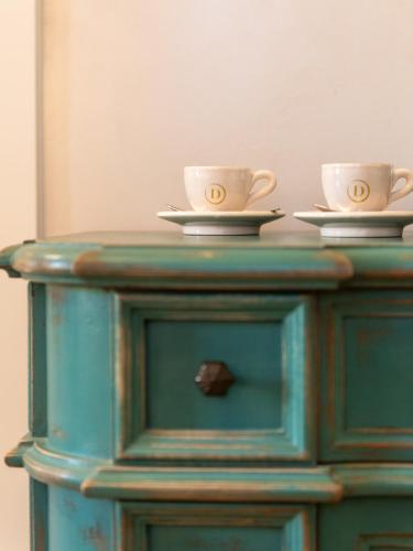 two coffee cups sitting on top of a wooden cabinet at Palazzo Doni by Florence Art Apartments in Florence