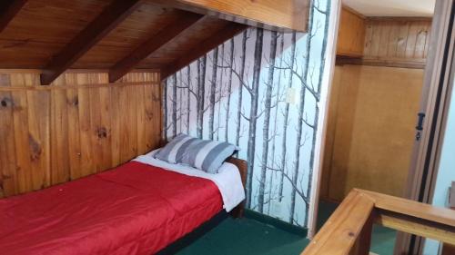 a room with a bed with a wall with trees on it at Triplex a dos cuadras del mar in Necochea