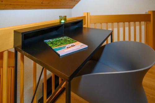 a black table with a book and a chair at Galeriewohnung in Menzenschwand in Menzenschwand-Hinterdorf