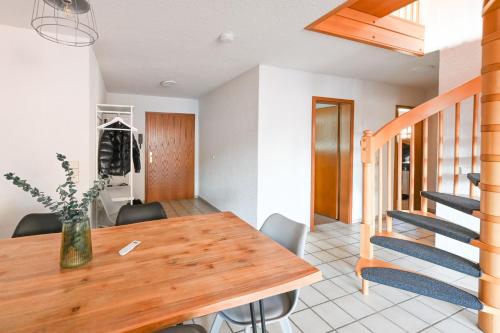 a dining room with a wooden table and a staircase at Galeriewohnung in Menzenschwand in Menzenschwand-Hinterdorf