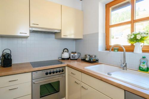 a kitchen with white cabinets and a sink at Galeriewohnung in Menzenschwand in Menzenschwand-Hinterdorf