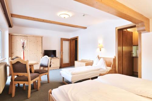 a hotel room with two beds and a desk at Heiterwanger Hof Appartments in Heiterwang