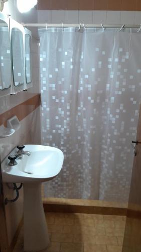 a bathroom with a sink and a shower with a shower curtain at Triplex a dos cuadras del mar in Necochea