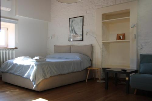 a bedroom with a bed and a blue chair at Alle scalette in Trieste