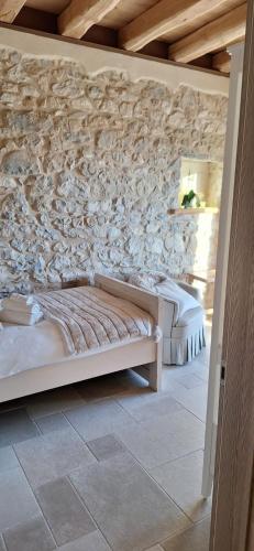 two beds in a room with a stone wall at Agriturismo La Pina in Tarzo