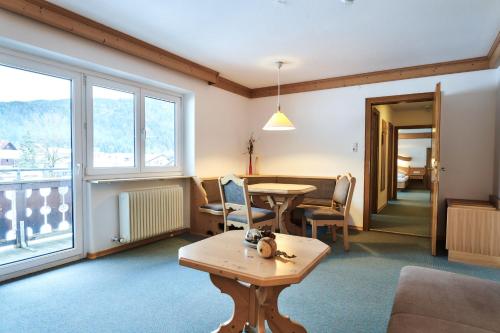 a living room with a table and chairs and a window at Heiterwanger Hof Appartments in Heiterwang