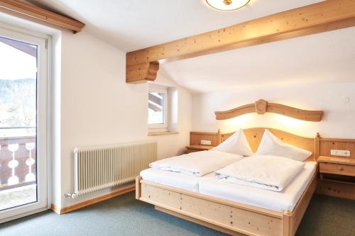 a bedroom with a bed and a large window at Heiterwanger Hof Appartments in Heiterwang
