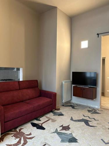 a living room with a red couch and a flat screen tv at casa greta in Viareggio