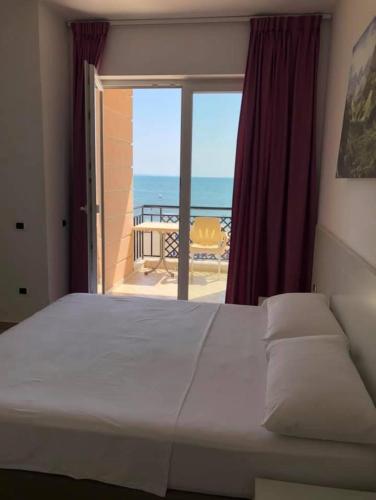a bedroom with a bed and a view of the ocean at Hotel Brilant in Shëngjin