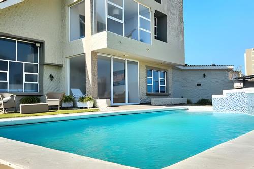 a swimming pool in front of a house at Casa de playa privada Sabanilla 4 cuadras del mar in Maizal