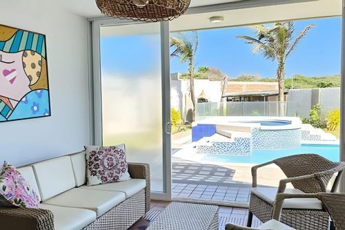 a living room with a couch and a patio at Casa de playa privada Sabanilla 4 cuadras del mar in Maizal